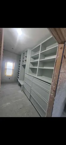 Another angle of the built-in closet, with open shelving and drawer fronts.