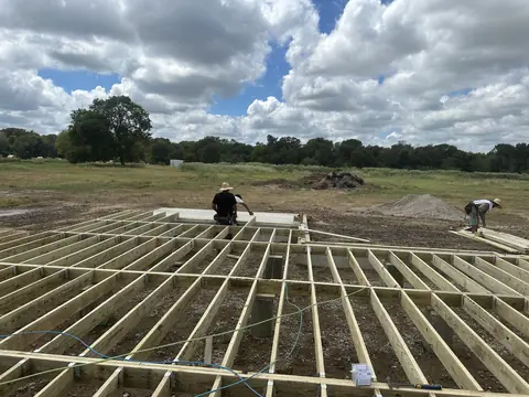 Wide view of the developing floor-framing grid in East Texas.