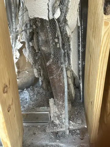 Deteriorated masonry and exposed reinforcement at the storefront repair area.