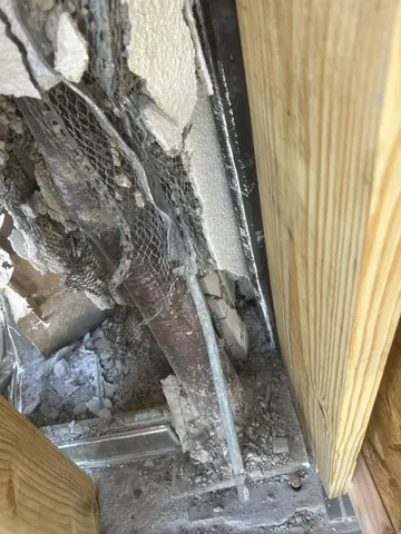 Closer view of damaged masonry between temporary wood support posts.
