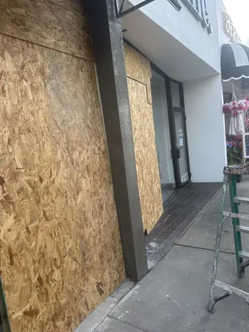 Boarded storefront opening during structural repair.