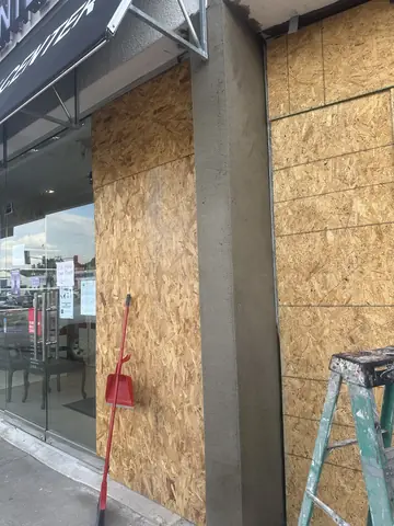 Exterior view of the supported and boarded storefront repair area.
