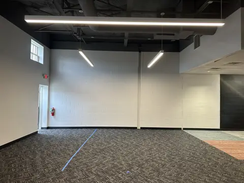 Fitness room with carpet and layout tape before work begins.