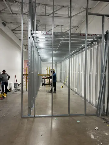 Steel-stud framing forming an interior corridor during a commercial build-out.