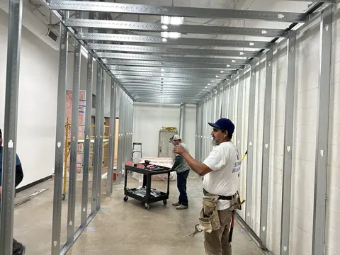 Crew installing steel-stud framing for the commercial interior.