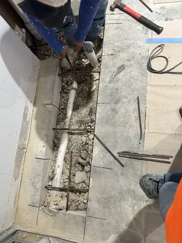 A floor trench being prepared during commercial interior work.