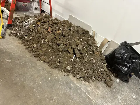 Excavated material beside an opened floor trench.