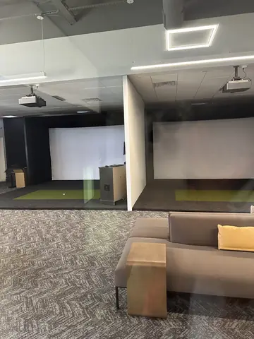 Simulator bays and lounge seating as the fitness interior takes shape.