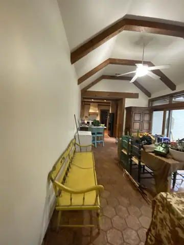 Ceiling beams and protected furnishings during residential painting.