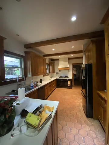 Kitchen ceiling, cabinetry, and tile flooring during the painting project.