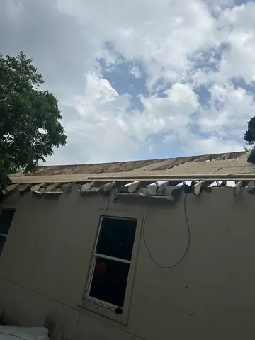 Roof sheathing removed above the residential exterior wall.