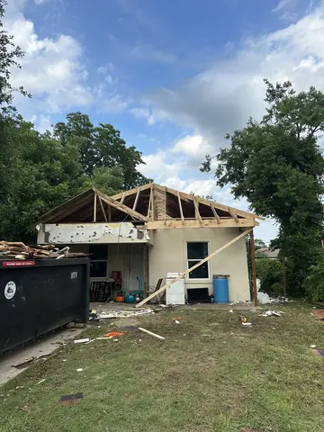 New roof framing rising above the home during construction.