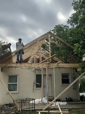 Roof framing work in progress over the residential addition.