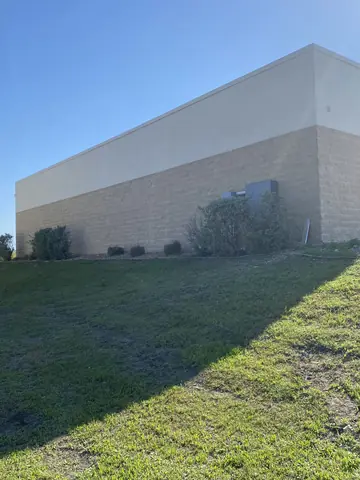 Freshly painted exterior wall viewed from the landscaped side of the property.