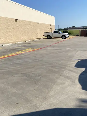 Commercial parking area beside the painted exterior wall.
