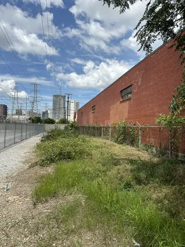 Exterior site conditions beside a brick commercial building.