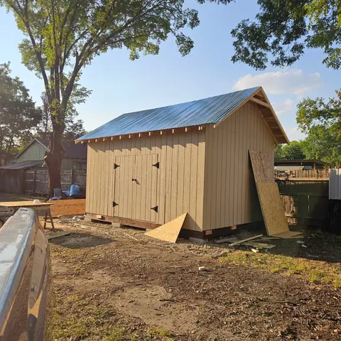Completed storage building with board-and-batten siding and a metal roof.