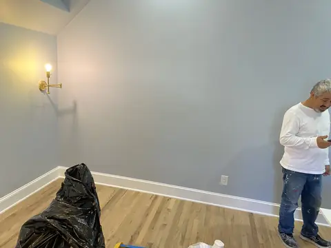 Gray walls, white base trim, wood flooring, and a wall sconce in the residential room.