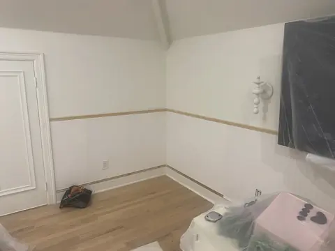 White wainscoting and chair rail installed around a residential room.