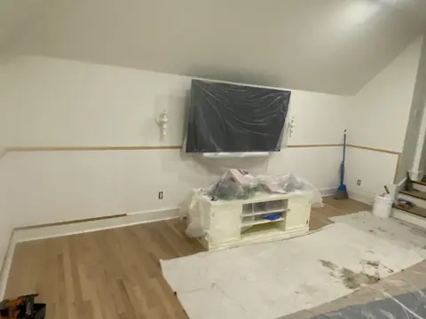 Wall paneling and trim behind a covered screen and protected furnishings.