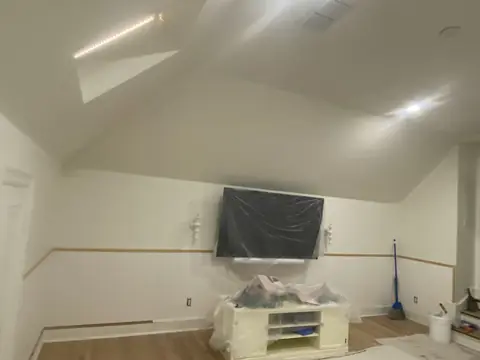 Sloped ceiling and recessed lighting above the room during finishing.