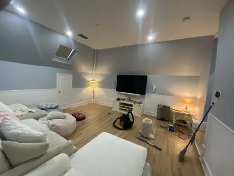 Finished room with wood flooring, gray walls, and recessed lighting.