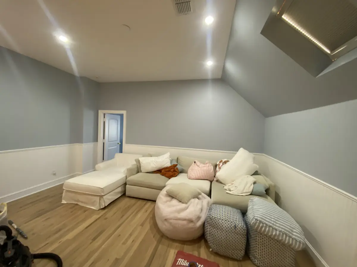 Finished residential living room with sectional seating and refinished wood floors